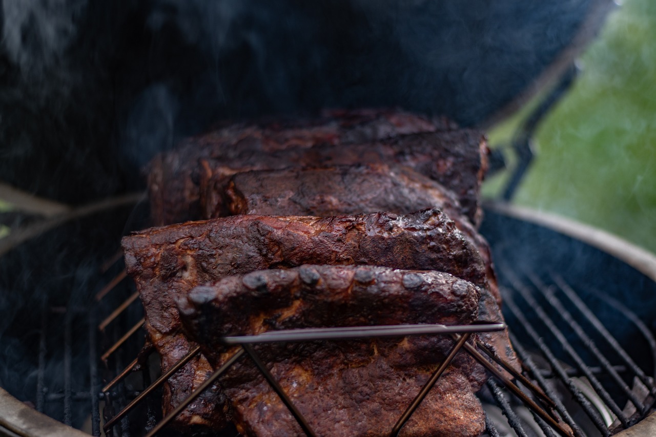 Racks of ribs smoking on a grill grate